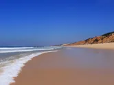 The Atlantic ocean washing onto a deserted sandy beach, on the Alentejo coast, Comporta, Portugal. 
